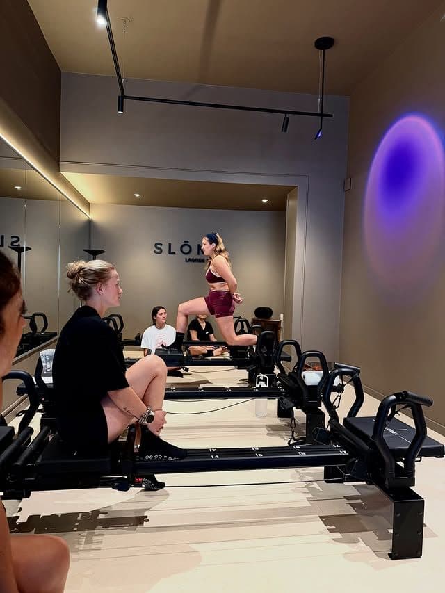 Une stagiaire réalise un exercice debout sur une Micro Pro, observée par le groupe